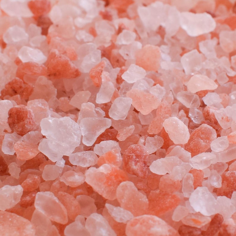 May include: Close-up of pink Himalayan salt crystals. The salt is a mixture of small and large crystals, with a range of pink and white hues.