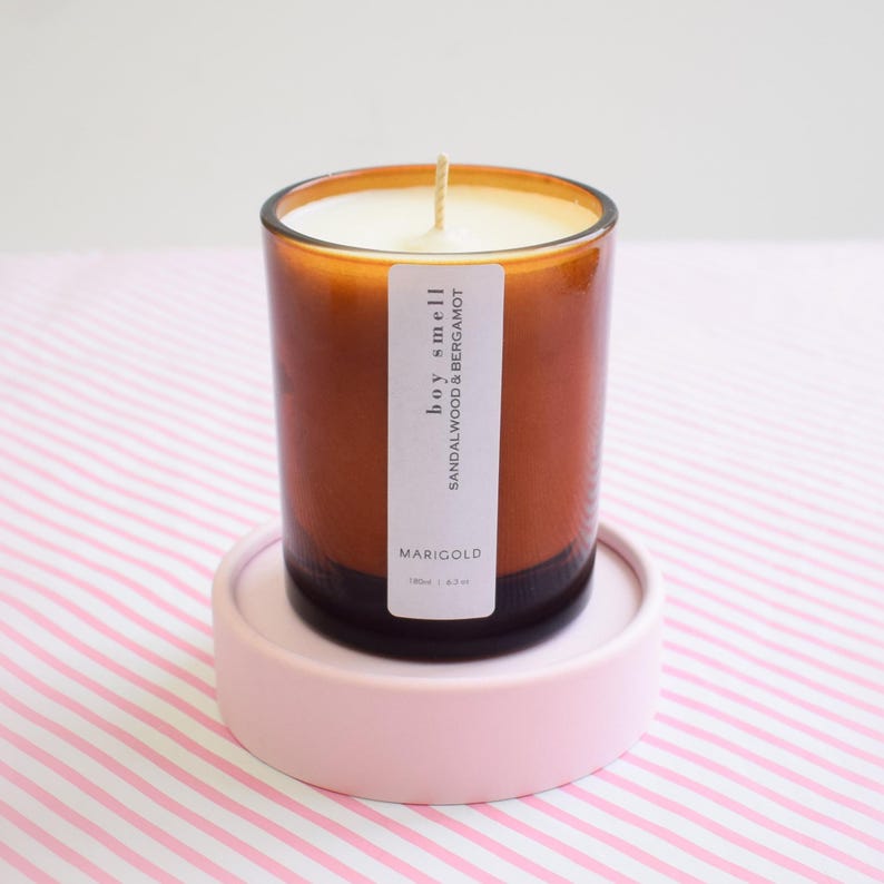 Sandalwood and bergamot candle in amber jar on a stripped tablecloth,