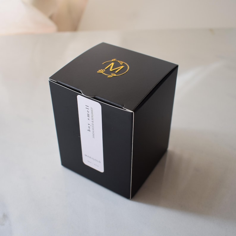 sandalwood and bergamot candle in amber jar box with gold logo