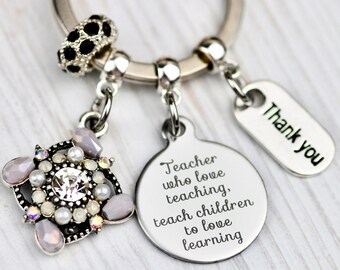 May include: Silver keychain with a charm that says "Teacher who love teaching, teach children to love learning" and another charm that says "Thank you".