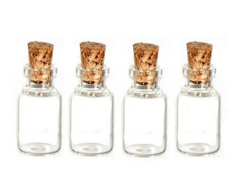 May include: Four small, clear glass bottles with cork stoppers. The bottles are rectangular with rounded corners and a narrow neck. The corks are a light brown color and fit snugly into the bottle openings. The bottles are arranged in a row against a white background.