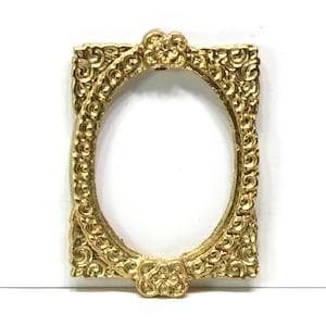 May include: A gold-colored, ornate picture frame with an oval opening. The frame features intricate scrollwork and floral accents at the top and bottom. The rectangular frame is designed with a classic, vintage aesthetic.