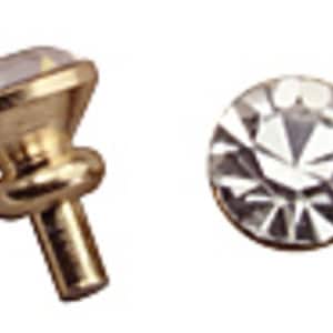 May include: Two pieces of jewelry: a gold-colored stud earring with a clear, faceted gemstone and a single, round, clear, faceted gemstone. The earring has a decorative, gold-colored base.