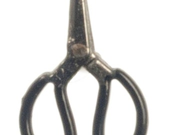 May include: A small, black pair of scissors with rounded handles and pointed blades. The scissors are made of a dark, possibly metallic material, and are set against a plain white background.