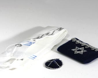 May include: A white prayer shawl with black text and blue stripes, a navy blue velvet kippah, and a navy blue velvet bag with a silver Star of David and trim. Religious items.