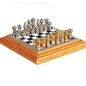May include: A complete chess set with silver and gold-colored pieces on a black and white checkered board. The board is set on a wooden base, showcasing a classic strategy game.