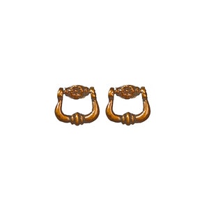 May include: Two antique bronze-colored drawer pulls. Each pull has a decorative center piece and a curved handle. The pulls are designed for furniture restoration or adding a vintage touch to cabinets and drawers.