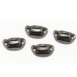 May include: Four small, dark gray metal drawer pulls. Each pull has a curved, rectangular handle with two small holes on either side for screws. The pulls are slightly distressed, giving them a vintage appearance.