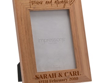May include: A wooden photo frame with the inscription "Forever and always" and a heart symbol. The frame is designed to hold a 5x7 inch photo and has a personalized inscription that reads "Sarah & Carl 12th February 2010".