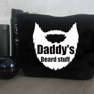 May include: Black zippered pouch with a white graphic of a beard and the text "Daddy's Beard Stuff".