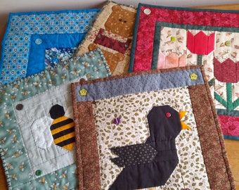 Five small hand-sewn patchwork wall quilts/table mats