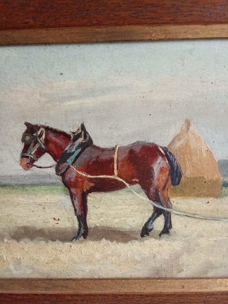 May include: Oil painting of a brown horse harnessed for work in a field. The horse stands in a field with a haystack in the background. The painting is framed in a dark wood frame.