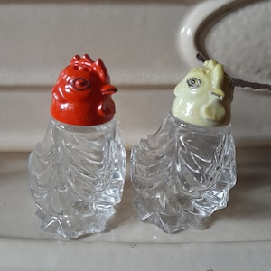 Peut inclure: Une paire de salières et poivrières vintage. L'une a une tête de coq rouge, l'autre une tête de coq jaune pâle. Les corps en verre transparent sont texturés. Un ajout charmant à toute cuisine ou table à manger.
