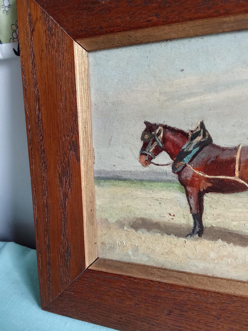 May include: Oil painting in a wooden frame depicting a brown horse with tack. The horse stands in a field under a cloudy sky. The painting has a vintage aesthetic, with visible brushstrokes and a warm color palette.