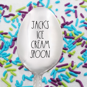 May include: A silver ice cream spoon with the text "JACK'S ICE CREAM SPOON" engraved on the bowl. The spoon is surrounded by colorful sprinkles.