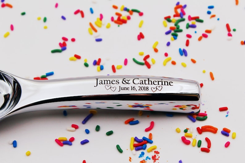 Op de afbeelding: Een zilveren ijslepel met de inscriptie "James & Catherine June 16, 2018" op het handvat.