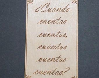 May include: A wooden sign with the text "¿Cuando cuentas cuentos, cuántos cuentos cuentas?" in a decorative script font.