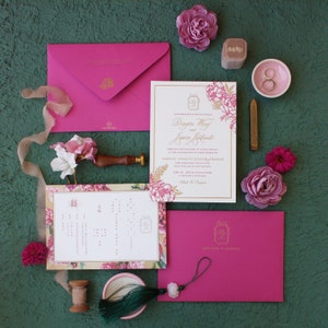 Invitación de boda impresa en tipografía: lámina dorada, impresión tipográfica fucsia, impresión digital en acuarela, monograma, sello de lacre, sobre con plan de color fucsia
