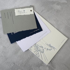 Invitación de boda impresa con tipografía: impresión tipográfica azul, lámina plateada, remache plateado, bordes desbarbados, sello de lacre gris, dirección para los invitados