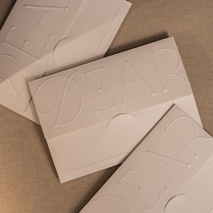 Muestra de tarjeta con mensaje impreso en tipografía: relieve ciego, impresión digital, plegado, troquelado, sobre