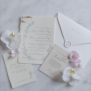 Invitación de boda impresa en tipografía: papel hecho a mano, bordes barbados, impresión tipográfica gris, papel dorado, sobre en relieve, sello de lacre y tarjeta de menú