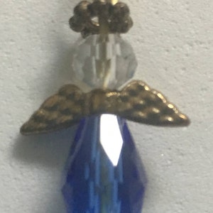 Op de afbeelding: Een gouden engelbedel met een blauw kristallen lichaam en gouden vleugels. De engel heeft een helder kristallen hoofd en een gouden kroon.