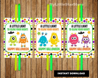 Può includere: Tre biglietti di Halloween con mostri dei cartoni animati e la scritta "A LITTLE LIGHT TO GLOW YOUR NIGHT!" e "HAPPY HALLOWEEN." Ogni biglietto ha un design di mostro diverso e un bastoncino verde.