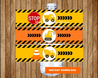 May include: Three printable water bottle labels featuring construction vehicles. The labels have a yellow and black striped background with a stop sign, a construction cone, and a dump truck. The text "INSTANT DOWNLOAD" is on the bottom label.