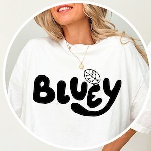 Könnte beinhalten: Weißes T-Shirt mit einer schwarzen Grafik auf der Vorderseite, die "Bluey" mit einem Blatt auf dem "y" sagt. Die Rückseite des Shirts hat eine Checkliste mit folgenden Punkten: "Have a little cry", "Pick myself up", "Dust myself off" und "And keep going".