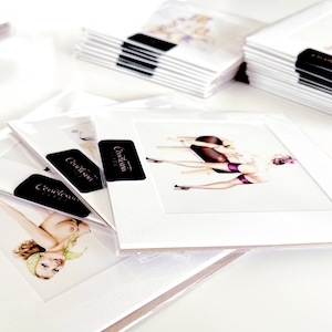 May include: A stack of white cards with black text that reads "Creatasun" on each card. The cards are stacked on a white surface. The cards are blank on the front and back.