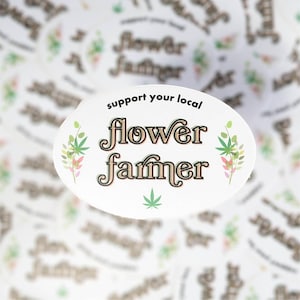 Peut inclure: Autocollant ovale blanc avec le texte "soutenez votre producteur de fleurs local" en lettres brunes et vertes avec une feuille de cannabis stylisée au centre.