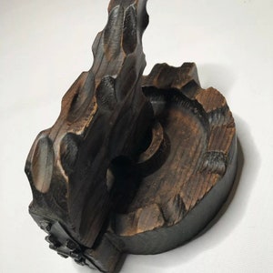 May include: A dark brown wooden hand-carved mold for making traditional food items. The mold is made of two pieces that fit together. The mold is in the shape of a circle with a raised edge.