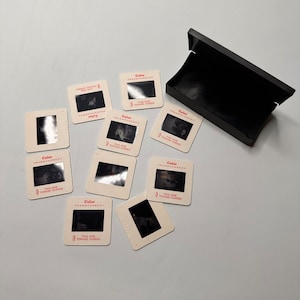 May include: A collection of eight color transparency slides in a black plastic slide case. The slides are labeled "Color Transparency" and "This Side Toward Screen".