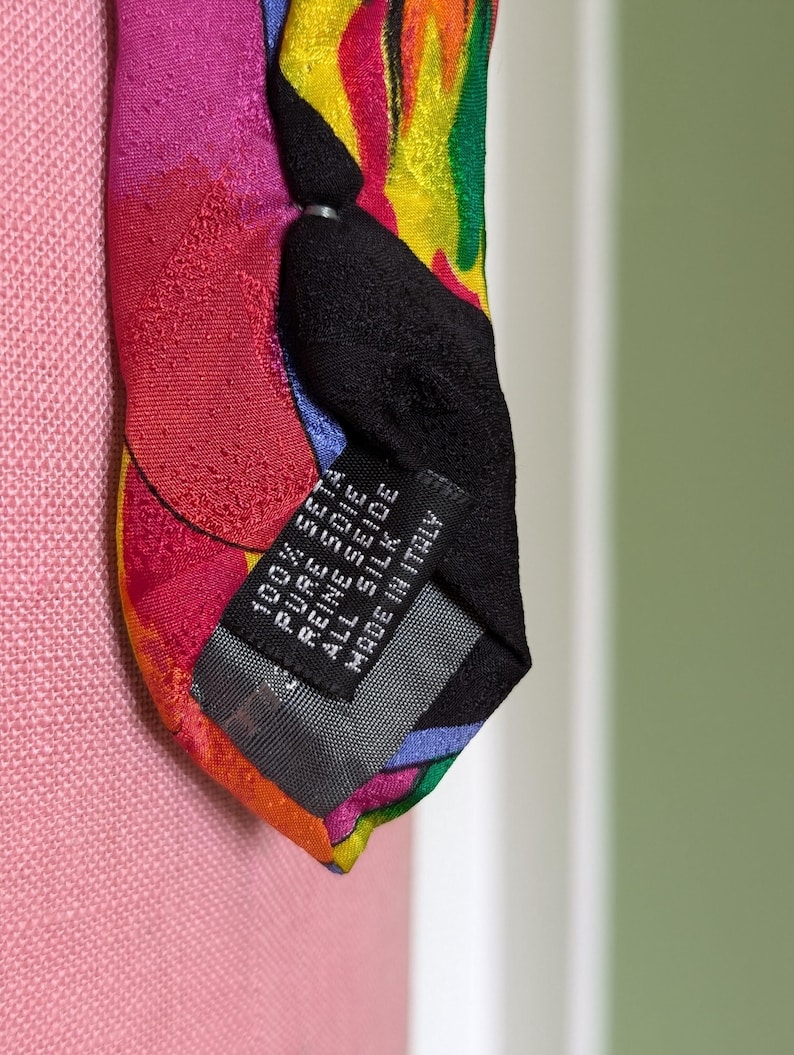 May include: A colorful silk tie with a black label that reads "100% SETA PURE SEIDE ALL SILK MADE IN ITALY".