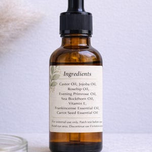 May include: A brown glass bottle with a black dropper top, containing a clear liquid. The label lists ingredients like Castor Oil, Jojoba Oil, and Vitamin E. The bottle is likely a skincare product.