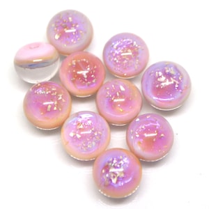May include: Ten iridescent pink glass beads with a shimmery finish. The beads are round and have a slightly translucent appearance.