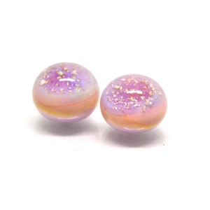 May include: Two small, round, iridescent glass beads with a pink and purple color scheme. The beads have a speckled appearance with gold flecks.