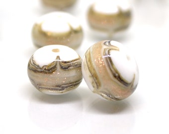 May include: White glass beads with brown and gold swirling patterns. The beads have a speckled, glittery finish.