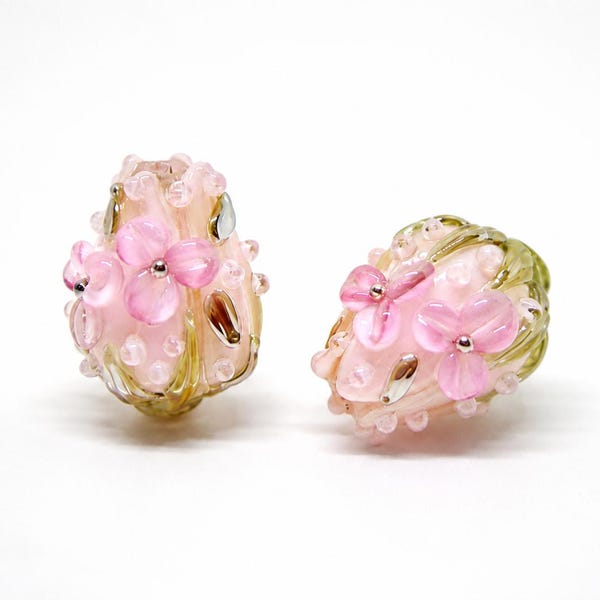 Pink flower bud lampwork beads with light green leaves — delicate handmade glass beads for jewelry making.