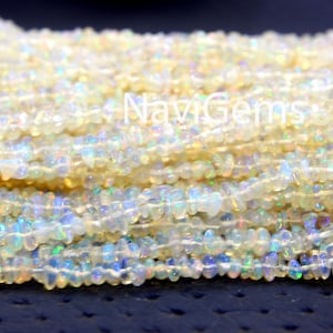May include: A strand of white opal chip beads. The beads are small and irregular in shape, with a slight iridescent sheen.