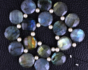 May include: A strand of iridescent labradorite gemstone beads with a pearlescent sheen, interspersed with white pearl beads. The beads are strung on a black cord and are arranged in a circular pattern.