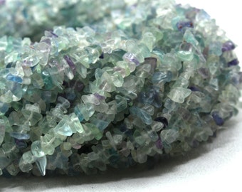 May include: A strand of light green, blue, and purple chip beads. The beads are irregular in shape and have a translucent appearance.