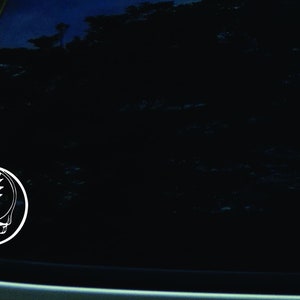 Könnte beinhalten: Weißer Vinyl-Aufkleber mit dem legendären Blitzkopfschädel-Logo der Grateful Dead auf einem schwarzen Autofenster.