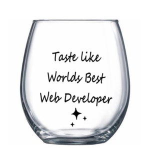 May include: Clear glass wine glass with the text "Taste like Worlds Best Web Developer" and two small stars printed on the bottom.
