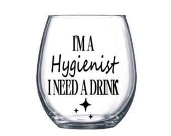 May include: A clear glass wine glass with the text "I'm a Hygienist I need a drink" printed in black.