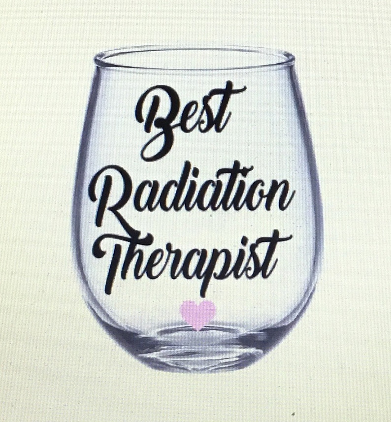 May include: A clear glass wine glass with the text "Best Radiation Therapist" in black lettering and a pink heart at the bottom.