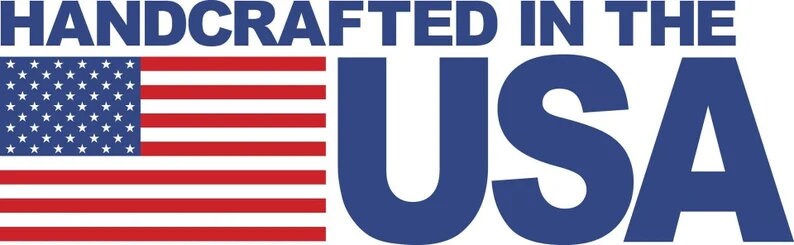 Puede incluir: La imagen muestra el texto "HANDCRAFTED IN THE USA" en azul oscuro. A la izquierda, la bandera estadounidense con rayas rojas y blancas y un campo azul con estrellas blancas. El texto indica el origen del producto.