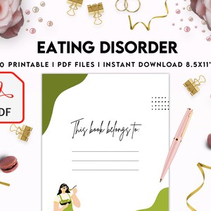 May include: A printable PDF workbook for eating disorder recovery. The cover features a green and white design with the text "This book belongs to:" and a line for writing. The image also includes a pink pen, macarons, and a gold ribbon.