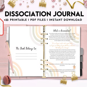K&ouml;nnte beinhalten: Ein rosa-wei&szlig;es Journal mit einem Regenbogen-Design auf dem Cover. Der Titel des Journals lautet "Dissociation Journal" und der Untertitel lautet "+33 Printable I PDF Files I Instant Download". Das Journal ist auf einer Seite mit dem Titel "What is Dissociation?" und einer Beschreibung der Dissoziation ge&ouml;ffnet.