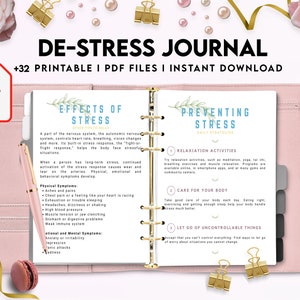 May include: A pink and white printable journal with the title "De-Stress Journal" and the text "+32 Printable I PDF Files I Instant Download". The journal has a gold spiral binding and features sections on the effects of stress and preventing stress.